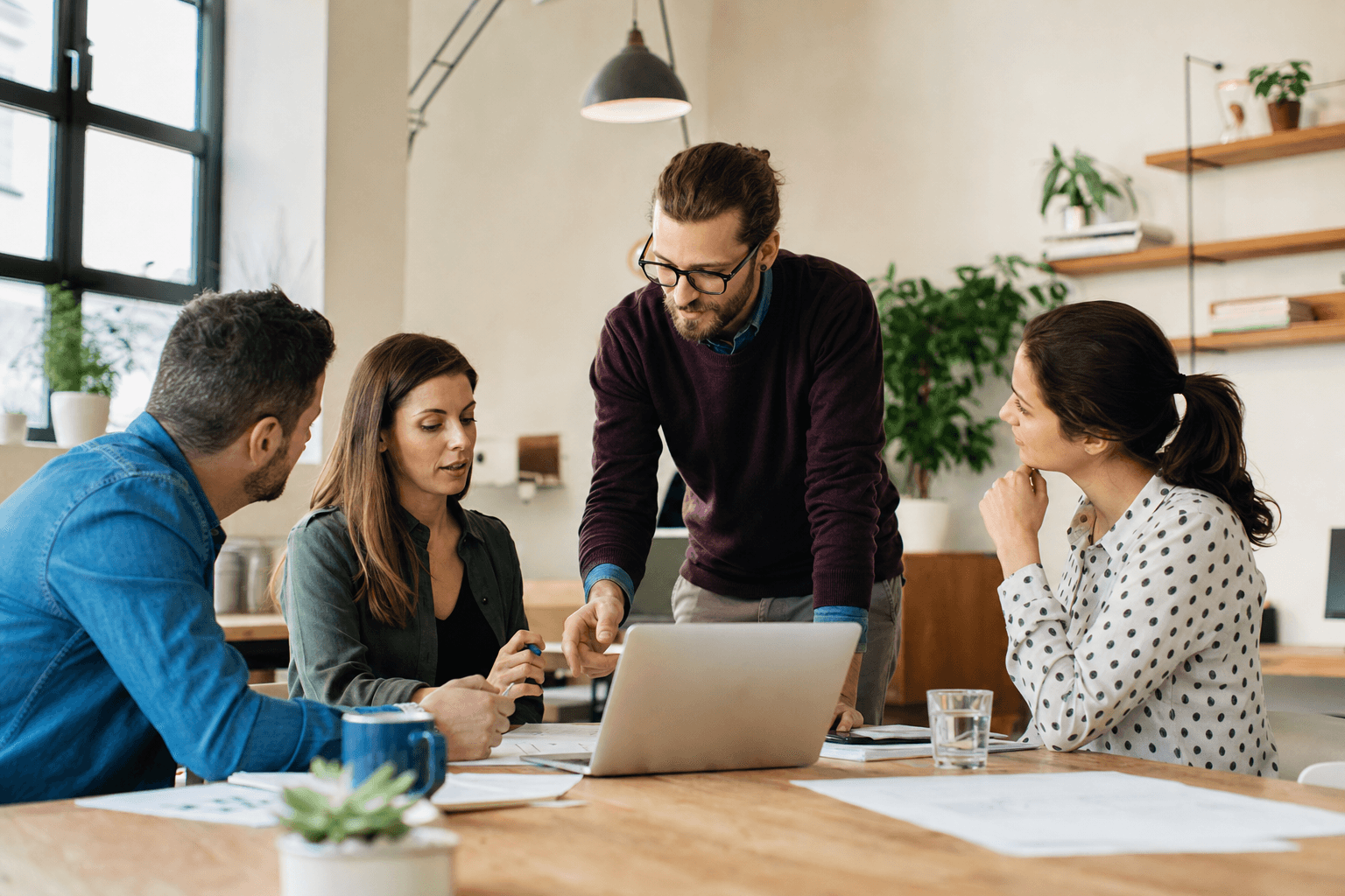 Small business leadership team discussing an operational issue in a modern office